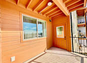 Thumbnail 19 of 27 - A wooden deck with a door and a balcony.