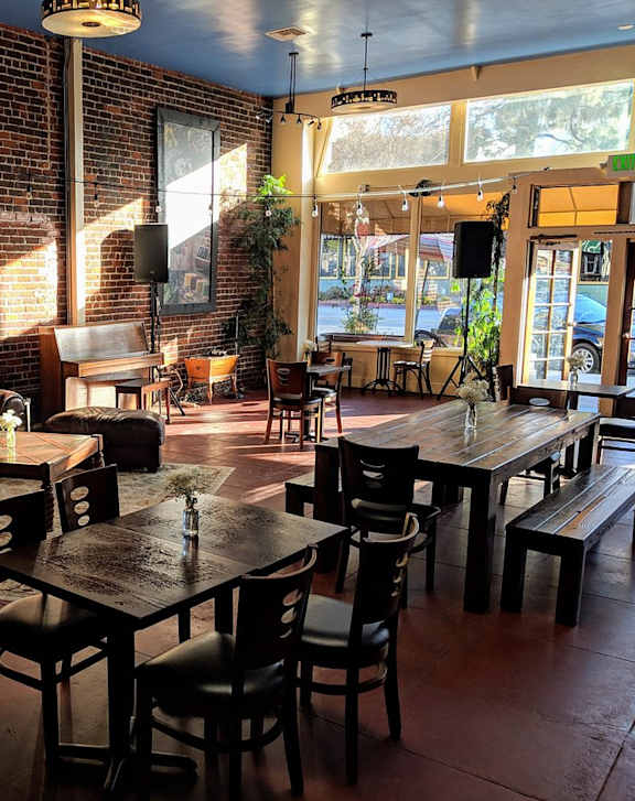 A restaurant with a brick wall and wooden tables.