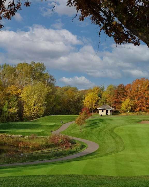 A beautiful golf course surrounded by trees in autumn.