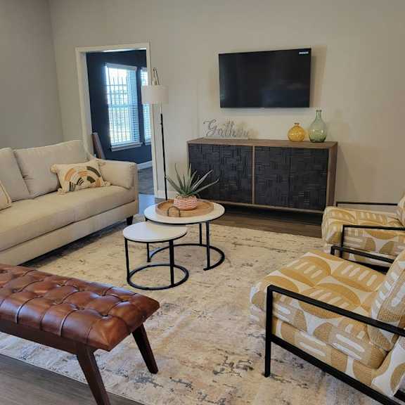a living room with a couch and chairs and a television