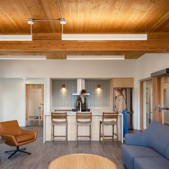 A modern interior with a wooden ceiling and a red railing.