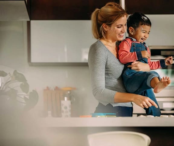 a woman holding a child in a kitchen at Assembly Park Apartments,Telford, TELFORD WREKIN