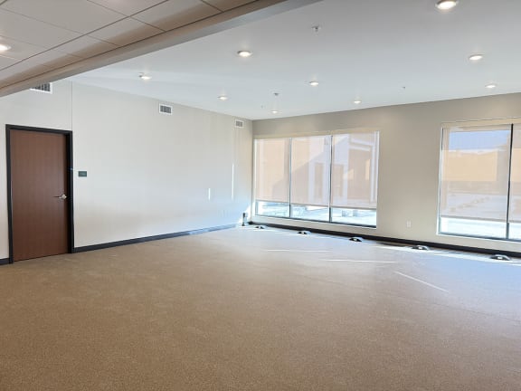 an empty gym space with a door and large windows