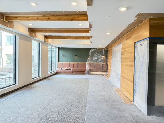 a large room with a large window and brown leather booth seating along back wall