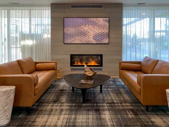 A living room with a fireplace and a painting above it.