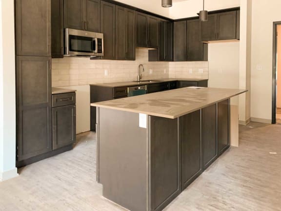 an empty kitchen with a large island in the middle