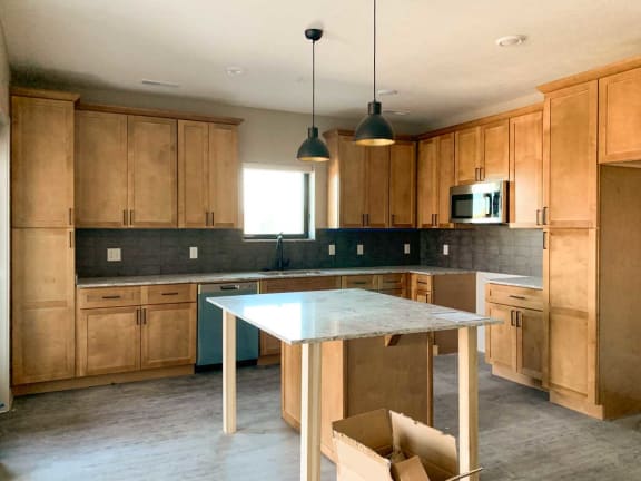 a large kitchen with wooden cabinets and a white island