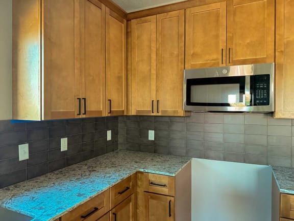 a kitchen with warm tan cabinets and beige counters