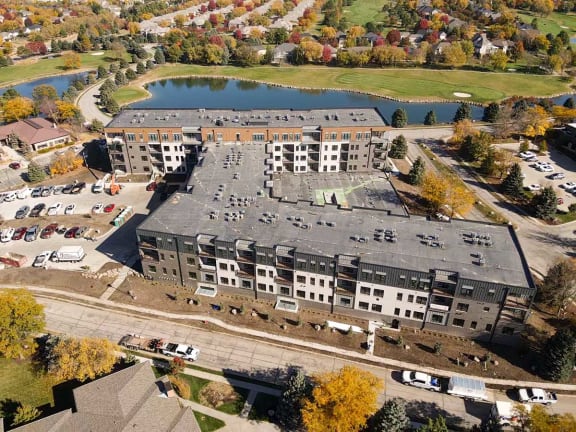 an aerial view of a building next to a lake