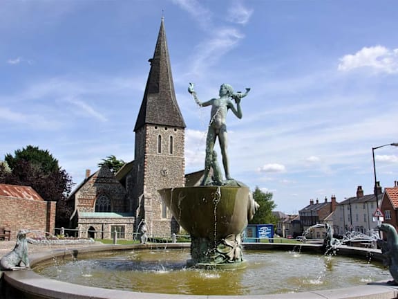 a fountain with a statue in front of a church