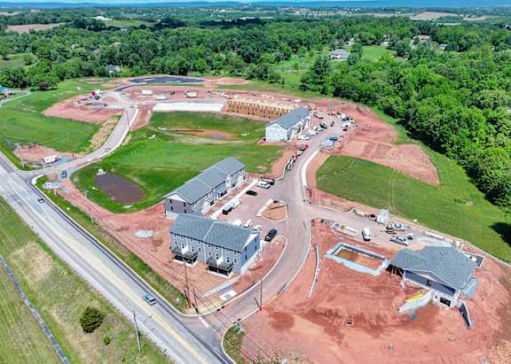 A construction site with a large building and a parking lot.