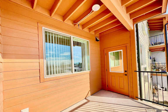A wooden deck with a door and a balcony.