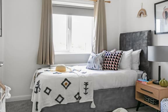 a bedroom with a bed with a blanket and pillows