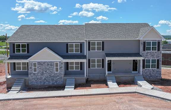 A modern house with a grey roof and stone accents.