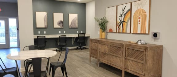 a communal area with a table and chairs and a reception desk