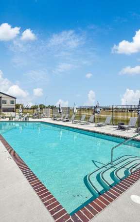 A pool area with sun loungers and umbrellas.