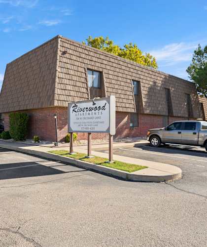 A building with a sign that says "Riverwood Estates" in front of it.