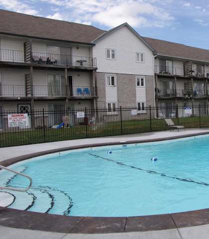 A swimming pool in front of apartment buildings.
