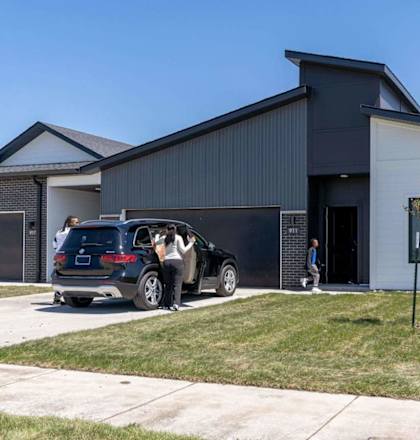 A modern house with a car parked in front.