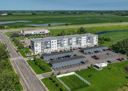A large building complex with a parking lot in front.
