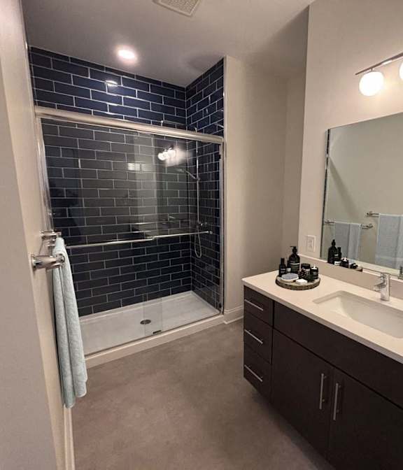 A bedroom with a bed, a ceiling fan, and a window. at The Annex Apartments, Buffalo, NY, 14222