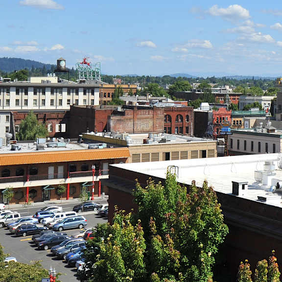 A parking lot with cars and a building with a red roof.
