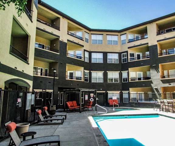 The outdoor pool with pool chairs, tables, and chairs at Citifront Apartments. 