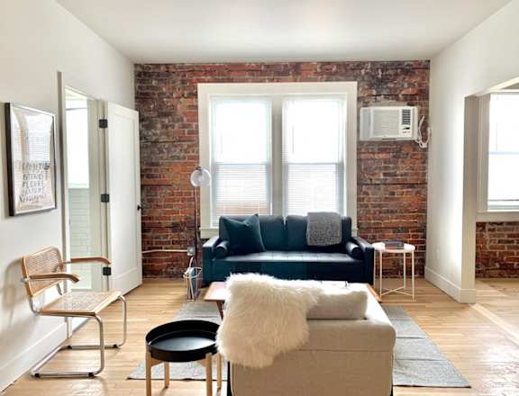 a living room with a couch and a brick wall