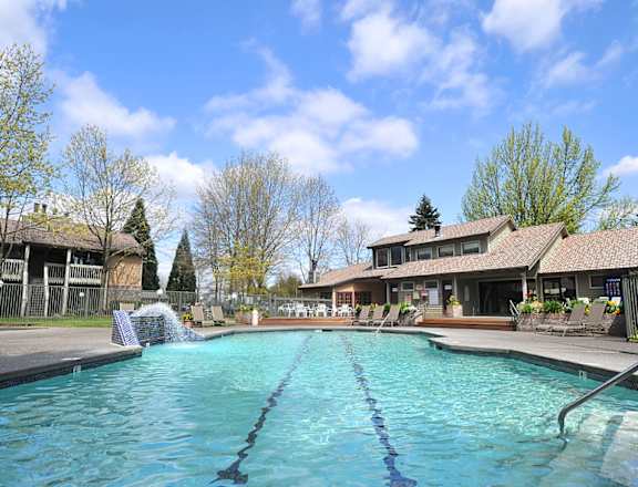 Stone Creek a large swimming pool with a fountain in front of a house