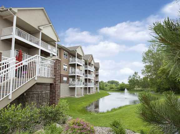 Apartment complex with a pond in the front.