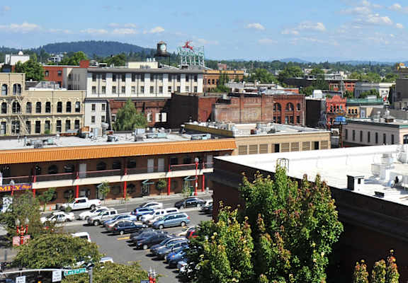 A parking lot with cars and a building with a red roof.