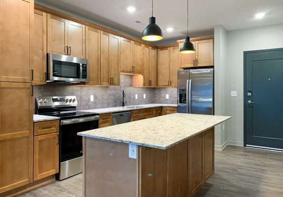 A kitchen with wooden cabinets and a granite countertop.