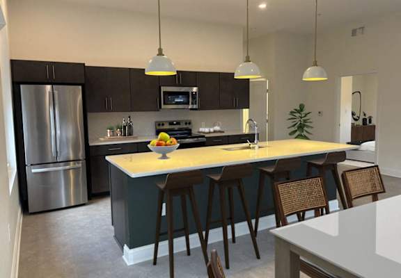 A kitchen with a large island and bar stools. at The Annex Apartments, Buffalo, NY, 14222