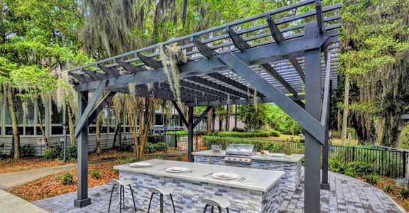 a patio with a fire pit and a pergola