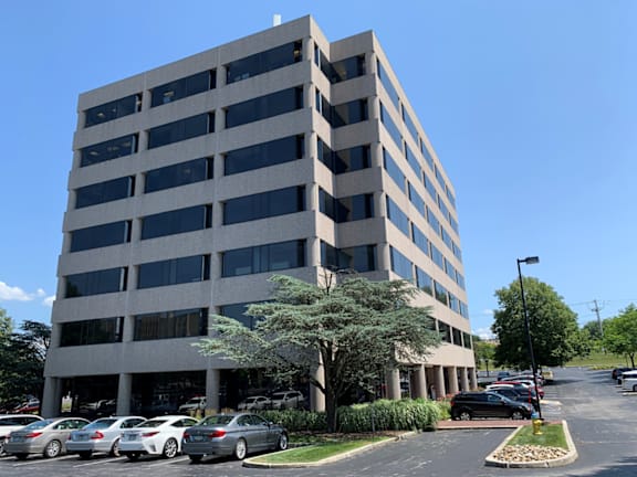 an office building with cars parked in a parking lot