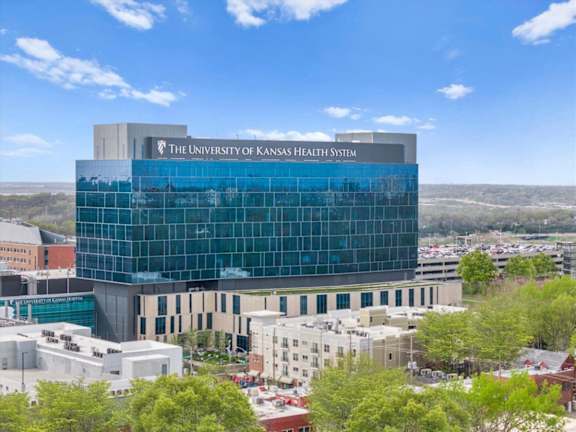 The University of Kansas Health System building is a large, modern structure with a glass facade.