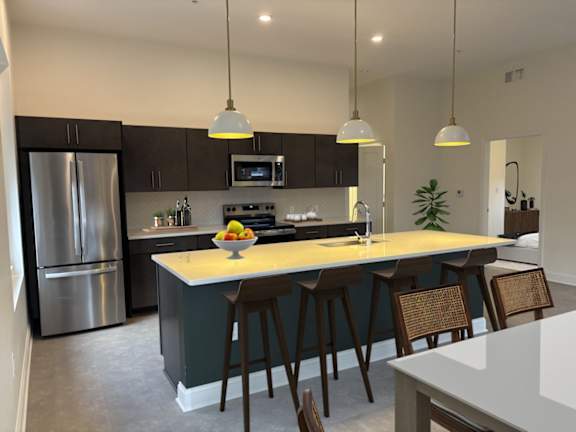A kitchen with a large island and bar stools.