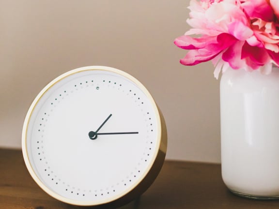 Clock and flowers on table at Mirabella Apartments, CA, 92203
