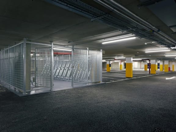 a parking garage with white and yellow columns and gates