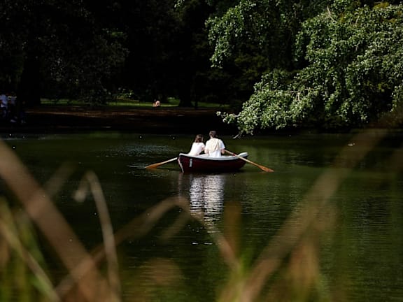 two people are sitting in a boat on a lake