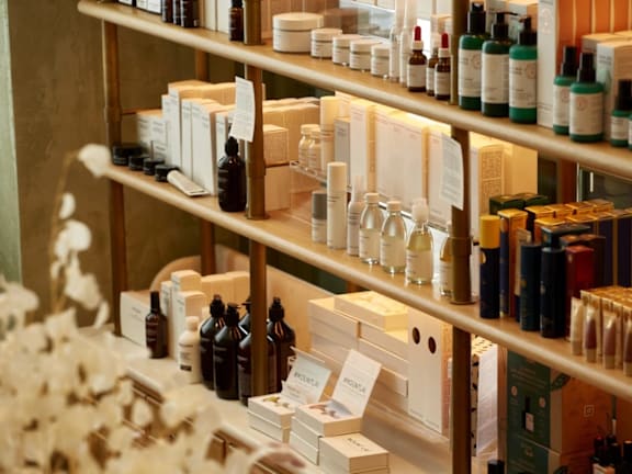 a shelf filled with lots of bottles of hair products