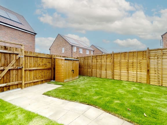 a wooden fence in a backyard with a green lawn