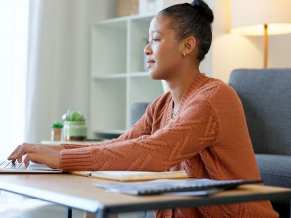 a woman sitting at a desk using a laptop computer
