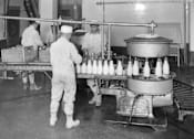 Thumbnail 1 of 8 - A black and white photo of workers in a factory.
