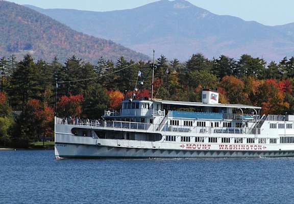 A large white boat with the words Mount Washington on the side is sailing on a body of water.