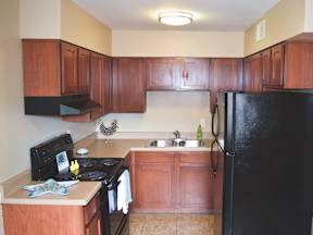 A kitchen with wooden cabinets and black appliances.at Maplehurst Apartments, Knoxville Tennessee