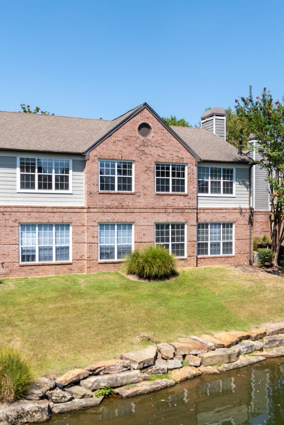 a brick house with white siding and a grassy yard at The Grove Germantown in Germantown, TN