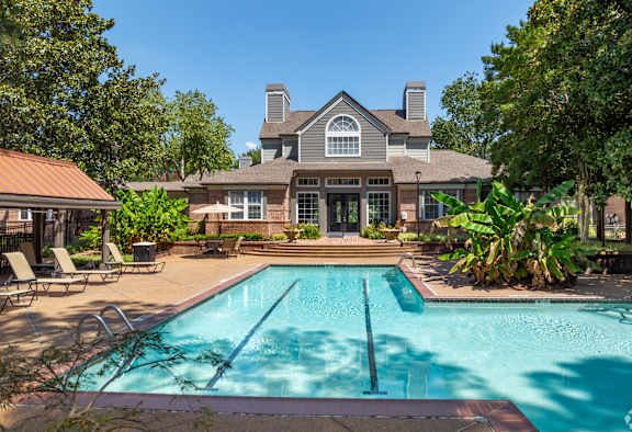 a swimming pool with a house in the background at The Grove Germantown Apartments, Tennessee, 38138