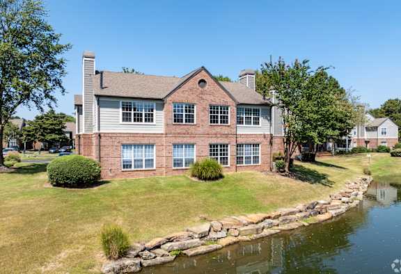 a large brick house with a river in front of it