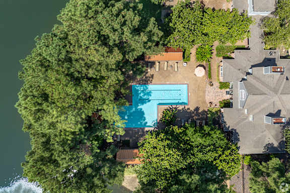 a backyard with a pool and trees and a house